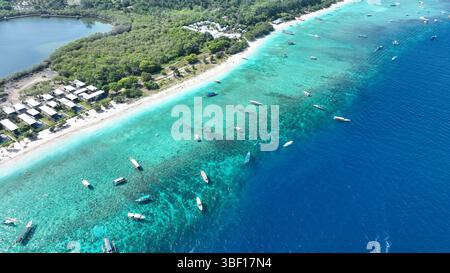 Tropische Insel mit weißem Sandstrand und blauem transparentem Wasser und Korallenriffen. Luftschießen, Schnellboote, Longtail-Boote, Gili Trawangan Island Stockfoto