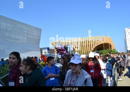 EXPO Mailand 2015. Sonniger Blick auf den französischen Pavillon mit zahlreichen Besuchern, die in der Warteschlange stehen, um ihn zu betreten. Umweltfreundliches City-Konzept. Der Pavillon des Heiligen Stuhls ist links. Stockfoto