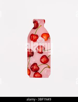Sommerkomposition mit frischen roten Kirschen und Eiswürfeln, sichtbar durch eine flaschenförmige Lücke auf rosa Hintergrund. Minimales kreatives Kirschsaft-Konzept Stockfoto