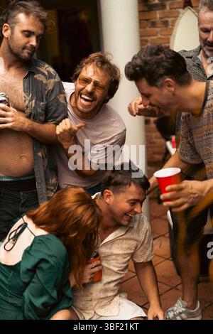 Eine Gruppe von Freunden, die sich auf der Party aufhalten und einen lebendigen, lustigen Moment teilen Stockfoto