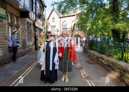 Die alte Tradition des Rushbearing. Eine Prozession vom Dorfzentrum, die den Dingle hinaufführt zur St. Mary's Church, wo Morris-Tänzer untergehen Stockfoto