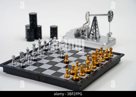 Ein Schachbrett mit Stücken, ein Ölpumpenheber und Ölfässer. Strategie, Wirtschaft, politisches Spiel und Diplomatie. Stockfoto