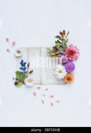 Ein floraler Herbst Stillleben Flachbild mit Blumen, Blättern, Vintage alten Seiten, auf weißem Leinwandhintergrund, mit leerem Platz zum Schreiben Stockfoto
