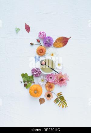 Ein lebhaftes Herbststillleben mit Blumen, Blättern, Teetasse und Teelöffel und leerem Platz Stockfoto