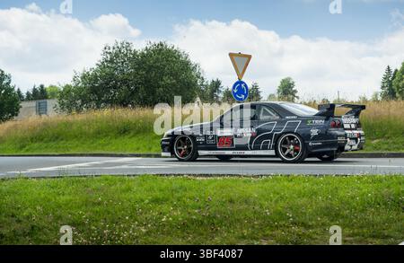Trafiic im Nürburgring: Seitenansicht der Nissan Skyline R33 GT-R, die sich dem Kreisverkehr nähert Stockfoto