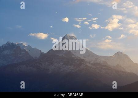 Besucher bewundern das atemberaubende Himalaya-Panorama vom Poon Hill aus, während die Sonne untergeht und ein warmes Leuchten über die schneebedeckten Gipfel und das sanfte va wirft Stockfoto