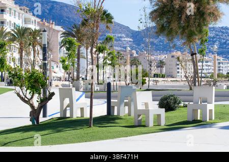 Moderne Strandpromenade mit weißen Bänken und Spielplatz. Altea ist eine malerische Küstenstadt in Spanien, Marina Baixa, Provinz Alicante, Spanien Stockfoto