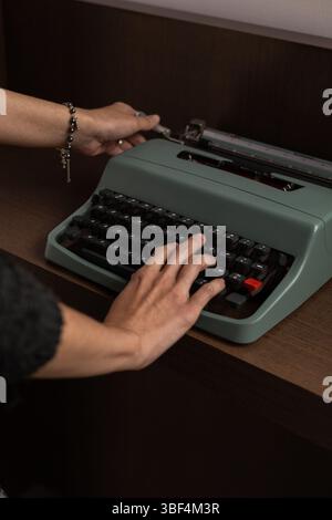 Eine Nahaufnahme von Händen, die aktiv Tasten auf einer Vintage-Schreibmaschine drücken. Dieses nostalgische Bild fängt den Charme der analogen Schrift ein und erinnert an Creativi Stockfoto