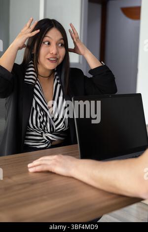 A captivating portrait of a young woman with her hands framing her forehead, expressing anticipation and focus. The image conveys introspection and me Stockfoto