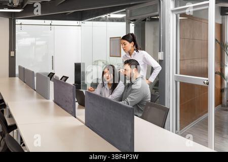 Drei Kollegen kommunizieren per Videoanruf mit einem Kunden aus dem Ausland und zeigen Engagement und Professionalität in einem hellen Büro. Stockfoto