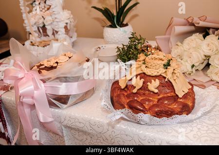 Ein wunderschön gestalteter Hochzeitstisch mit dekorativem Lavash-Brot, weißen Rosen und eleganten Blumenarrangements sorgt für einen festlichen AR Stockfoto