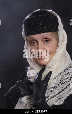 Reife Frau in Winterkleidung und weißem Schal Stockfoto