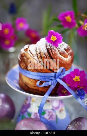 Süßes Osterbrot, Panettone oder Kruffin und bunt bemalte Eier, Weihnachtsfrühlingkonzept Stockfoto