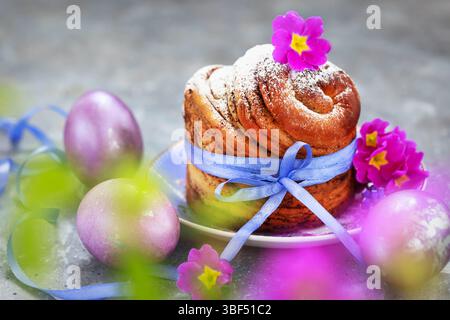 Süßes Osterbrot, Panettone oder Kruffin und bunt bemalte Eier, Weihnachtsfrühlingkonzept Stockfoto