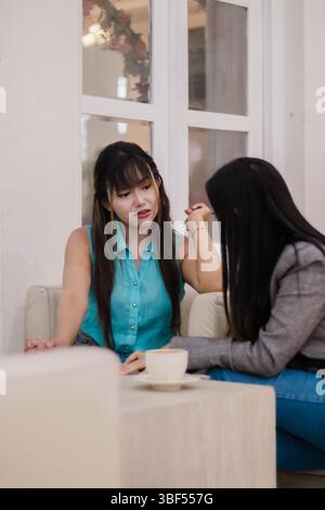 Zwei Freundinnen unterhalten sich bei einem Kaffee in einem Café. Halten Sie die Essenz von Freundschaft, Verbindung und modernem Lebensstil fest. Stockfoto