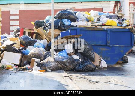 Müllcontainer Kartons und Beutel voller Müll und verschüttetem Müll Stockfoto