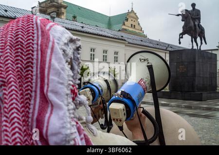 Ein Demonstrant, der einen keffiyeh-Gesang-Slogan durch ein Megaphon trug, während einer Demonstration vor dem Präsidentenpalast. Am Freitag, dem 30. Mai, versammeln sich eine Gruppe palästinensischer Aktivisten und Demonstranten im polnischen Präsidentenpalast in Warschau. Die Demonstranten tragen Banner, Plakate und Fahnen und versuchen, die Präsidentschaftskandidaten an die Präsidentschaftswahlen am Sonntag und ihre Wähler daran zu erinnern, dass der Völkermord in Gaza ein lebendiges und dringliches Thema ist. UN-Generalsekretär Antonio Guterres hat erklärt, dass "die Lage der Palästinenser im Gazastreifen unbeschrieben ist, Mo Stockfoto