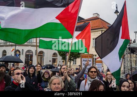 Demonstranten schwenken palästinensische Flaggen, während andere während einer Demonstration vor dem Präsidentenpalast Slogans singen. Am Freitag, dem 30. Mai, versammeln sich eine Gruppe palästinensischer Aktivisten und Demonstranten im polnischen Präsidentenpalast in Warschau. Die Demonstranten tragen Banner, Plakate und Fahnen und versuchen, die Präsidentschaftskandidaten an die Präsidentschaftswahlen am Sonntag und ihre Wähler daran zu erinnern, dass der Völkermord in Gaza ein lebendiges und dringliches Thema ist. UN-Generalsekretär Antonio Guterres hat erklärt, dass "die Lage der Palästinenser im Gazastreifen unbeschrieben ist, mehr noch Stockfoto