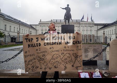 Ein Demonstrant singt pro-palästinensische Slogans, während er während einer Demonstration vor dem Präsidentenpalast ein handgefertigtes Banner hält. Am Freitag, dem 30. Mai, versammeln sich eine Gruppe palästinensischer Aktivisten und Demonstranten im polnischen Präsidentenpalast in Warschau. Die Demonstranten tragen Banner, Plakate und Fahnen und versuchen, die Präsidentschaftskandidaten an die Präsidentschaftswahlen am Sonntag und ihre Wähler daran zu erinnern, dass der Völkermord in Gaza ein lebendiges und dringliches Thema ist. UN-Generalsekretär Antonio Guterres hat erklärt, dass "die Lage der Palästinenser im Gazastreifen unbeschrieben ist Stockfoto