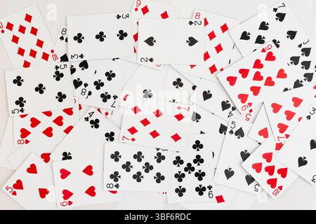 Verstreute Spielkarten mit gemischten Farben und Zahlen auf weißem Hintergrund Stockfoto