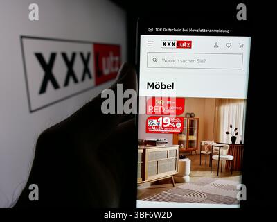 Deutschland. Mai 2025. In dieser Fotoabbildung hält eine Person ein Smartphone mit der Webseite des österreichischen Möbelunternehmens XXXLutz KG auf dem Bildschirm vor dem Logo. (Credit Image: © Timon Schneider/SOPA Images via ZUMA Press Wire) NUR REDAKTIONELLE VERWENDUNG! Nicht für kommerzielle ZWECKE! Stockfoto