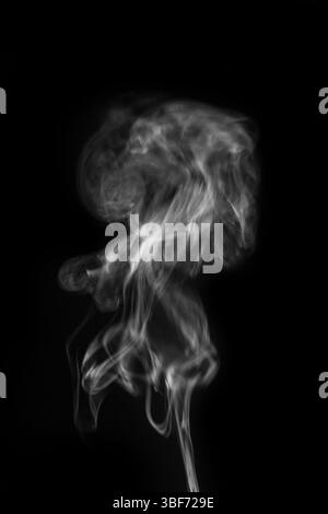 Ätherische Rauchfahnen, die anmutig vor dunklem Hintergrund schweben, schaffen ein fesselndes visuelles Erlebnis-Rauchkunst-Konzept. Grafikressource für Stockfoto