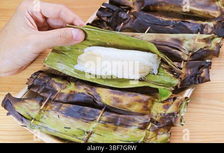 Bananenblatt von Khao Niao Ping, ein auf Holzkohle gegrillter thailändischer, gesüßter Kleberreis mit Füllungen Stockfoto