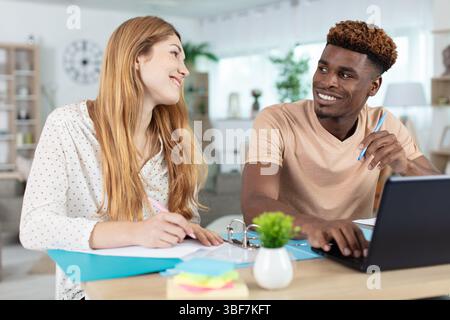 Gemischtes Paar, das im Haus Papierkram durchsucht Stockfoto