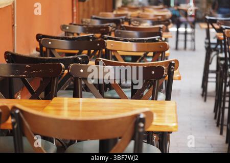 Stühle und Tische sind in einem gemütlichen Café im Freien angeordnet Stockfoto