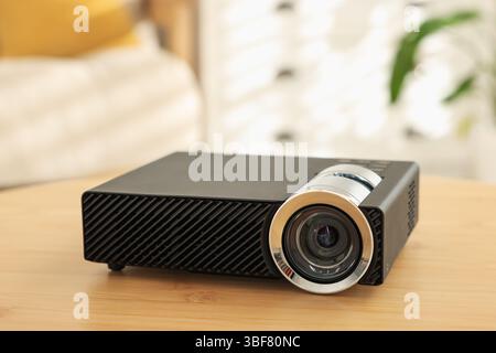 Moderner Videoprojektor auf Holztisch drinnen, Nahaufnahme Stockfoto