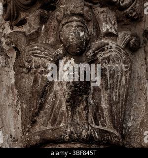 Sepia-farbene monochrome Ansicht von Kunstwerken eines anonymen, aber hoch angesehenen Bildhauers, bekannt als Meister von Agüero. Birdman mit menschlichem Gesicht und talonierten Füßen auf der Hauptstadt des berühmten spanischen romanischen Nordportals aus dem 12. Jahrhundert n. Chr. von Iglesia de San Salvador in Agüero, Provinz Huesca, Aragon, Spanien. An allen Schnitzereien der Eingangstüren sind Flecken von antiker Farbe erhalten. Stockfoto