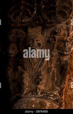 Bischof mit Sitz, der crozier hält, flankiert von Löwen mit menschlichen Gesichtern auf der spanischen romanischen Hauptstadt aus dem 12. Jahrhundert n. Chr., unterstützt Tympanon und Archivolte des Nordportals von Iglesia de San Salvador oder der Kirche San Salvador in Agüero, Provinz Huesca, Aragon, Spanien. Reich geschnitzte Tür, die dem Bildhauer zugeschrieben wird, der als Meister von Agüero bekannt ist. Stockfoto