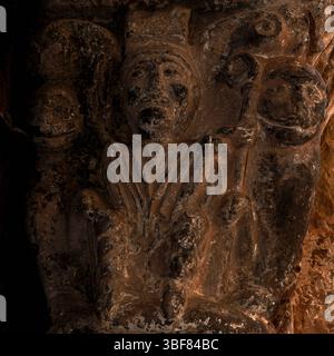Der Bischof, flankiert von Löwen mit menschlichen Gesichtern, hält crozier auf der spanischen romanischen Hauptstadt des 12. Jahrhunderts, die Tympanon und Archivolte des Nordportals von Iglesia de San Salvador oder der Kirche San Salvador in Agüero, Provinz Huesca, Aragon, Spanien, unterstützt. Reich geschnitzte Tür, die dem Bildhauer zugeschrieben wird, der als Meister von Agüero bekannt ist. Stockfoto