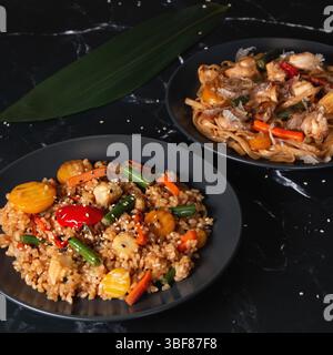 Asiatischer Reis und Nudeln auf schwarzem Hintergrund Stockfoto