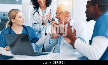 Ärzte, Mann und Team mit Applaus, Laptop und Unterstützung mit Zielen, Ergebnissen und Feier. Personen, Gruppen und Frauen mit Mitarbeitern für Erfolg, Lob oder Stockfoto