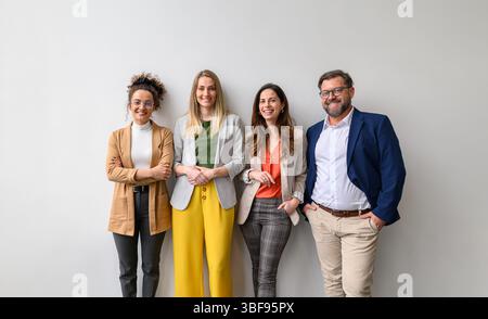 Porträt eines selbstbewussten Geschäftsmannes und weiblicher Profis, die glücklich zusammen auf weißem Hintergrund stehen Stockfoto