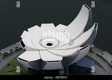 Das ArtScience Museum in Singapur, das 2011 eröffnet wurde, ist ein kultiges Kulturdenkmal am Marina Bay Sands. Das vom Architekten Moshe Safdie entworfene Lotus-inspirierte Gebäude verfügt über zehn fingerartige Erweiterungen mit 21 Galerien über 6.000 m? Das Museum beherbergt Ausstellungen, die die Schnittstelle von Kunst, Wissenschaft, Kultur und Technologie erkunden. Zu den nachhaltigen Merkmalen gehören ein oculus, der Regenwasser erntet, und eine natürliche Beleuchtung durch Oberlichter. Fotografiert von der Aussichtsplattform oben auf dem Marina Bay Sands Hotel. Stockfoto