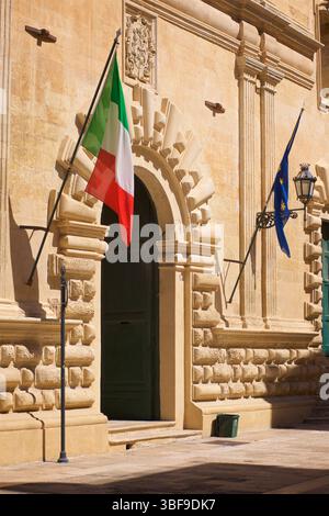 Eingang in Lecce, Apulien, Italien. Früher das Spirito Santo Krankenhaus. Heilig-Geist-Krankenhaus. Der Komplex beherbergt heute verschiedene kulturelle Einrichtungen. Italienische und europäische Flaggen auf beiden Seiten des Eingangs. Ex ospedale dello Spirito Santo, Via Giuseppe Libertini, 6, 73100 Lecce LE, Italien Stockfoto