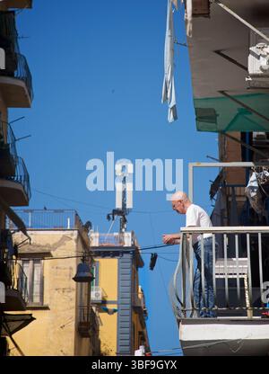 Mann, der auf einem Balkon steht in der Altstadt von Neapel, Neapel, Italien. Stockfoto