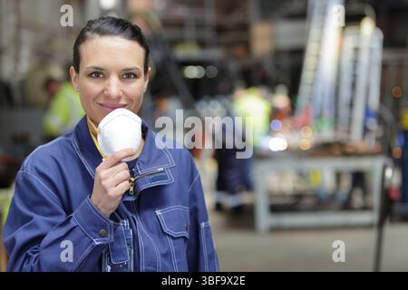 Porträt einer Fabrikarbeiterin mit Maske Stockfoto