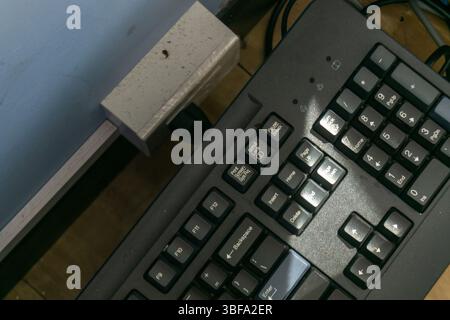 Detaillierte Nahaufnahme einer Computertastatur auf einem Schreibtisch mit Tasten und Elementen des Arbeitsbereichs, ideal für Technologie- und Bürothemen. Stockfoto