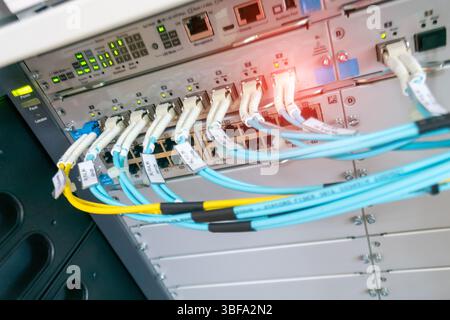 Dieses Bild zeigt eine Nahaufnahme der Netzwerkgeräte und der organisierten Kabel in einem Serverraum und hebt die kritische Infrastruktur für die digitale Welt hervor Stockfoto