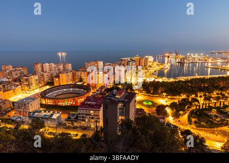 Blick auf Malaga bei Nacht. Eine wunderbare urbane Landschaft der Stadt Malaga in Spanien. Blick nach Sonnenuntergang, Stadtpanorama mit Stierkammerarena Stockfoto