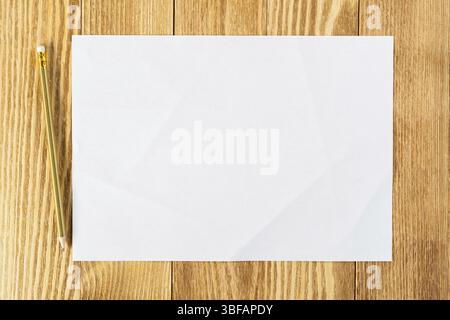 Blatt Papier liegen auf Holztisch. Leeres weißes DIN A4 Papier mit Bleistift. Platz zum Schreiben und Benachrichtigung. Strukturierte natürliche Holz- Hintergrund. Stockfoto