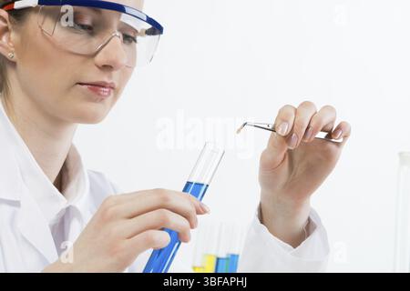 Wissenschaftler geben die Probe in das Reagenzglas mit Flüssigkeit. Biochemische Laboranalytik und Experimente. Nahaufnahme-Frauenhände, die Reagenzglas und Twee halten Stockfoto