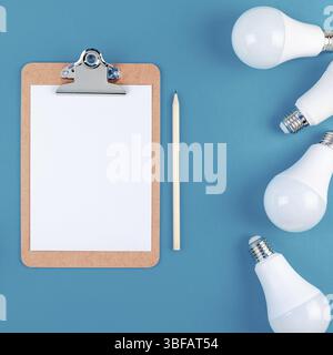Energiesparende und umweltfreundliche Leben in konzeptionelle Zusammensetzung. Kreative, oben flach von LED-Leuchten rahmen und leeres Papier in der Zwischenablage mit c Stockfoto