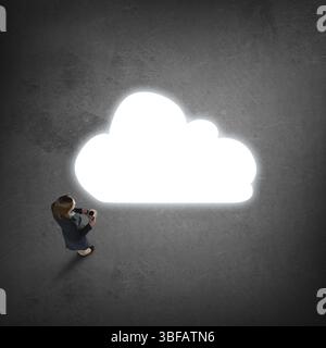Draufsicht auf eine durchdachte Geschäftsfrau, die das Cloud-Konzept auf betrachtet Boden Stockfoto