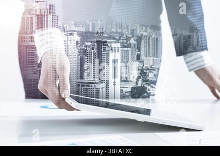 Geschäftsfrau, die in der Nähe des Büroschreibtisches steht und einen Tablet-Computer benutzt. Bank- und Finanzmanagement. Corporate Manager in Anzug, der mit Online-Bus arbeitet Stockfoto