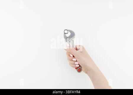 Kreative Bild der Frau hand mit Pastellfarben Maniküre polnischen Holding Schlüssel mit Kopie Raum auf weißem Hintergrund in minimalistischem Stil isoliert. Reparieren oder i Stockfoto