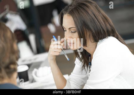 Junge Kollegen sitzen am Schreibtisch und diskutieren im hellen Büro Stockfoto